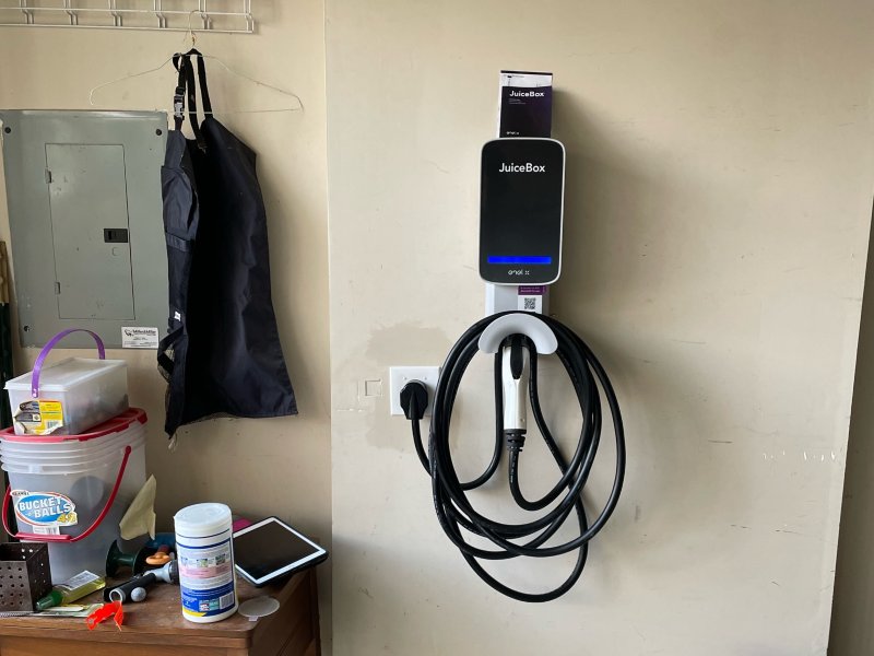 EV Charger hanging on wall next to items on desk and hanging on wall